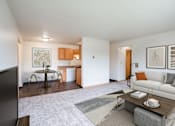 Thumbnail 2 of 20 - A living room with a couch, coffee table, and television. West Fargo, ND Saddlebrook Apartments