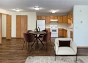 Thumbnail 7 of 16 - A kitchen with a table and chairs in the foreground. Bismarck, ND Sierra Ridge Apartments