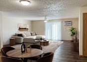 Thumbnail 8 of 16 - A living room with a brown table and chairs. Bismarck, ND Sierra Ridge Apartments