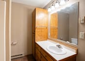 Thumbnail 9 of 13 - A bathroom with a sink, mirror, and lighting.