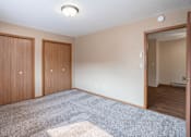Thumbnail 7 of 13 - A room with two doors and a carpeted floor.