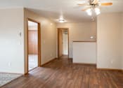 Thumbnail 5 of 13 - A room with a ceiling fan and wooden floors.