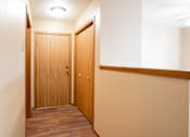 Thumbnail 11 of 13 - A hallway with two doors and a light on the ceiling.