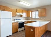 Thumbnail 3 of 13 - A kitchen with wooden cabinets and a white refrigerator.