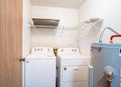 Thumbnail 8 of 13 - A small laundry room with a washer and dryer and a clothes drying rack.