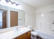Thumbnail 12 of 17 - A white bathroom with a sink, toilet, and bathtub. Fargo, ND Fieldstone Apartments
