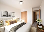 Thumbnail 5 of 17 - A bedroom with a large bed and a wooden door. Fargo, ND Fieldstone Apartments