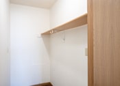 Thumbnail 13 of 17 - A white wall with a wooden shelf on it. Fargo, ND Fieldstone Apartments