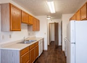 Thumbnail 8 of 17 - A kitchen with wooden cabinets and a white fridge. Fargo, ND Fieldstone Apartments