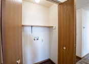 Thumbnail 14 of 17 - A white door with a round handle is open to a hallway. Fargo, ND Fieldstone Apartments