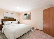 Thumbnail 6 of 6 - A bedroom with a large bed and a window. Bismarck, ND Parkview Arms Apartments