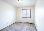Thumbnail 10 of 17 - A room with a window and a carpeted floor. Fargo, ND Southgate Apartments
