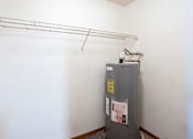Thumbnail 13 of 17 - a closet with a water heater and shelves. Fargo, ND Southgate Apartments