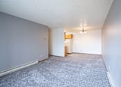 Thumbnail 6 of 17 - A room with a carpeted floor and a small wooden cabinet. Fargo, ND Southgate Apartments