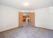 Thumbnail 39 of 54 - A room with a carpeted floor and a doorway leading to another room. Fargo, ND Stonebridge Apartments