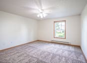 Thumbnail 22 of 54 - A room with a carpeted floor and a window. Fargo, ND Stonebridge Apartments