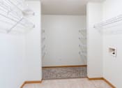 Thumbnail 25 of 54 - A laundry room with laundry hookups and shelves. Fargo, ND Stonebridge Apartments