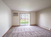 Thumbnail 17 of 54 - A room with a carpeted floor and a sliding glass door leading to a balcony. Fargo, ND Stonebridge Apartments