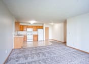 Thumbnail 18 of 54 - A kitchen with white appliances and wooden cabinets. Fargo, ND Stonebridge Apartments