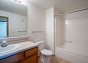 Thumbnail 16 of 54 - A white bathroom with a toilet, sink, and bathtub. Fargo, ND Stonebridge Apartments
