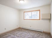Thumbnail 31 of 34 - A room with a window and a carpet on the floor. Fargo, ND Islander Apartments