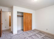 Thumbnail 32 of 34 - A room with a carpeted floor and a wooden door. Fargo, ND Islander Apartments