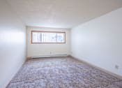 Thumbnail 26 of 34 - A room with a carpeted floor and a window. Fargo, ND Islander Apartments