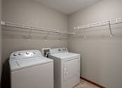 Thumbnail 16 of 48 - Two white front loading washing machines in a laundry room. Fargo, ND Urban Plains Apartments