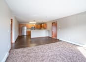 Thumbnail 13 of 48 - A kitchen with wooden cabinets and a refrigerator is visible. Fargo, ND Urban Plains Apartments