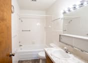 Thumbnail 8 of 10 - A bathroom with a toilet, sink, and bathtub. Fargo, ND Carr Apartments