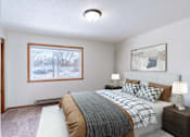 Thumbnail 4 of 10 - A bedroom with a large bed and a window overlooking a snowy street.  Fargo, ND Carr Apartments