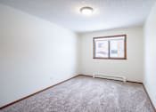 Thumbnail 15 of 42 - A room with a carpeted floor and a window. Fargo, ND Westwood Estates