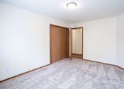 Thumbnail 16 of 42 - A room with a carpeted floor and a wooden door. Fargo, ND Westwood Estates