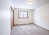 Thumbnail 17 of 42 - A room with a carpeted floor and a window. Fargo, ND Westwood Estates