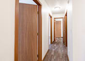 Thumbnail 19 of 42 - A long hallway with wooden doors on both sides. Fargo, ND Westwood Estates
