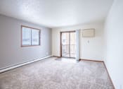 Thumbnail 10 of 42 - A room with a carpeted floor and a sliding glass door. Fargo, ND Westwood Estates