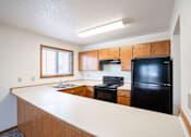 Thumbnail 7 of 42 - A kitchen with black appliances and wooden cabinets. Fargo, ND Westwood Estates