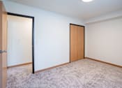 Thumbnail 43 of 46 - A room with a carpeted floor and two doors. Cherry Creek Apartments