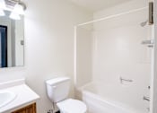 Thumbnail 22 of 23 - A white toilet sits next to a sink in a small bathroom.