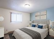Thumbnail 3 of 23 - A bedroom with a large bed and a window with blinds. Fargo, ND Countryside Apartments
