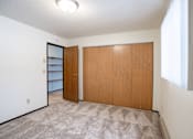 Thumbnail 19 of 23 - A room with a carpeted floor and two wooden doors.