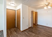 Thumbnail 19 of 20 - A room with wooden floors and three doors. Fargo, ND Kennedy Apartments