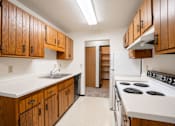 Thumbnail 15 of 23 - A kitchen with wooden cabinets and a white counter top.