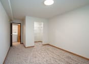 Thumbnail 34 of 46 - A carpeted room with a doorway leading to another room. Cherry Creek Apartments