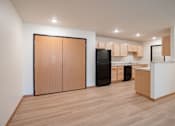 Thumbnail 29 of 46 - A kitchen with wooden floors and cabinets. Cherry Creek Apartments