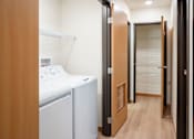 Thumbnail 35 of 46 - A laundry room with a washer and dryer. Cherry Creek Apartments