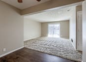 Thumbnail 24 of 34 - A room with a rug on the floor and a window with blinds. Omaha, NE Evergreen Terrace Apartments