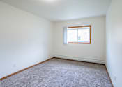 Thumbnail 17 of 39 - A room with a carpeted floor and a window. Grand Forks, ND Columbia West Apartments