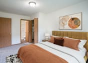 Thumbnail 3 of 39 - A bedroom with a large bed and a painting on the wall. Grand Forks, ND Columbia West Apartments