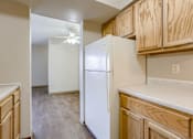 Thumbnail 17 of 29 - A kitchen with a white refrigerator and wooden cabinets. Omaha, NE Stony Brook Apartments